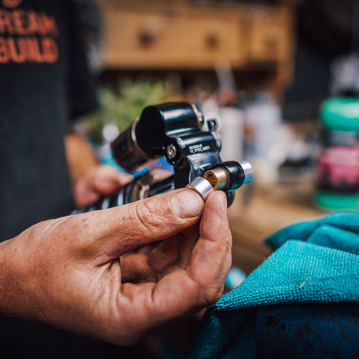 brass shock bushing kit being fitted to a rear shock eyelet